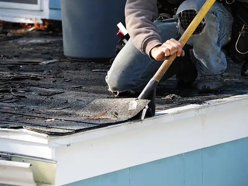 Worker removing old shingles